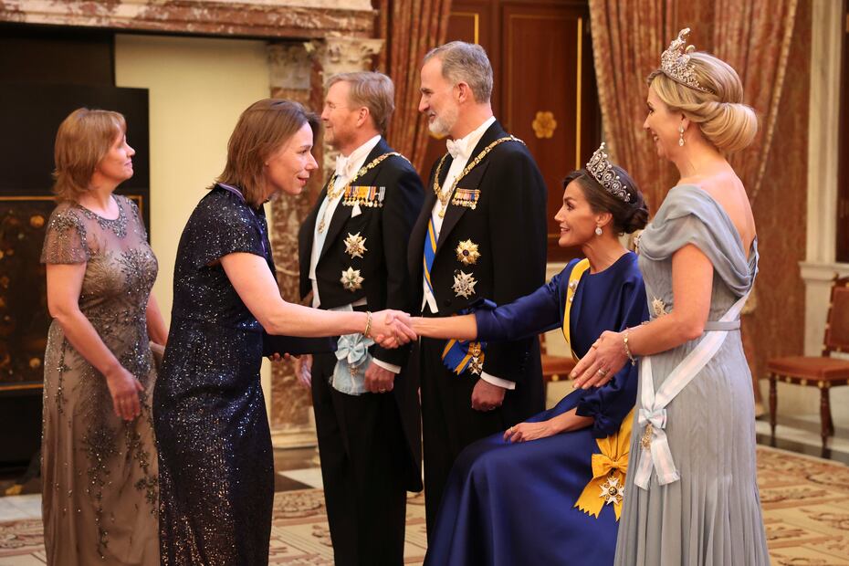 La dolencia que la reina Letizia (2d) sufre en su pie izquierdo, conocida como neuroma de Morton, le ha obligado a protagonizar una imagen insólita al participar sentada en el besamanos previo a la cena de gala ofrecida este miércoles por los reyes de los Países Bajos en el Palacio Real de Ámsterdam. EFE/ Casa De S.M. El Rey / José Jiménez