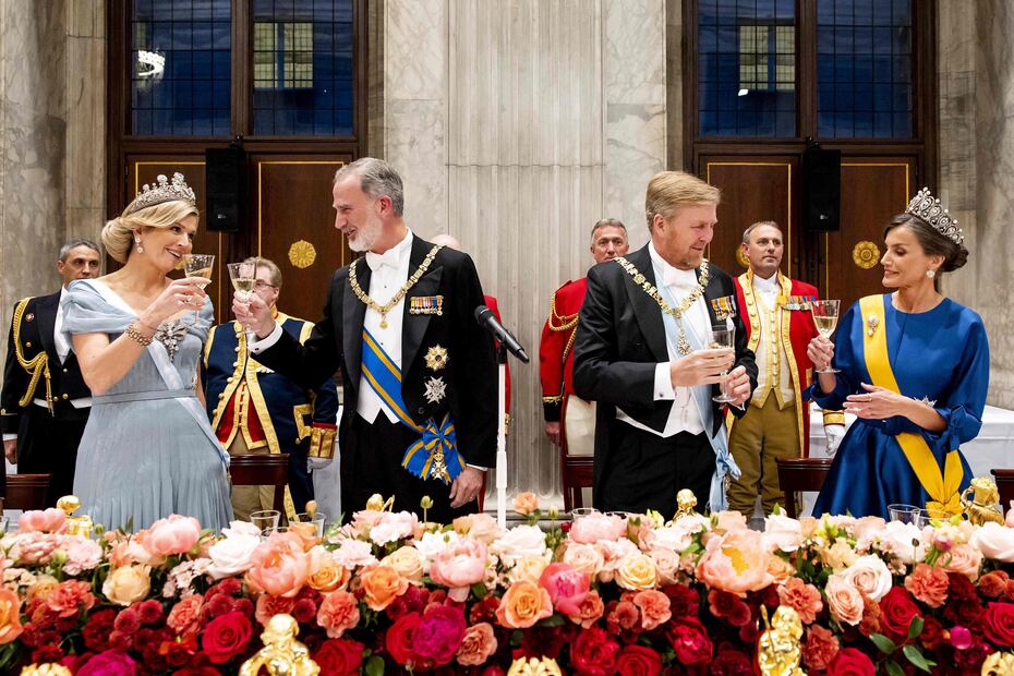 La dolencia que la reina Letizia (2d) sufre en su pie izquierdo, conocida como neuroma de Morton, le ha obligado a protagonizar una imagen insólita al participar sentada en el besamanos previo a la cena de gala ofrecida este miércoles por los reyes de los Países Bajos en el Palacio Real de Ámsterdam. EFE/ Casa De S.M. El Rey / José Jiménez