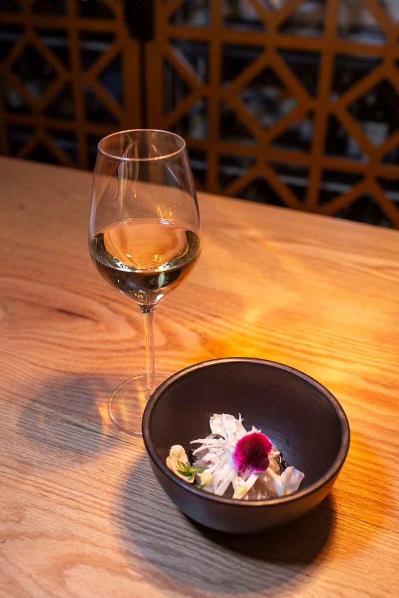 Ceviche blanco con pesca curada en kombucha, coco encurtido con vinagre de piña, mayonesa de nabo picante, consomé de corteza de queso y grasa de res ahumada acompañado con una copa de vino Guillaume Aurèle Blanc. (Foto: Esteban Torreblanca)