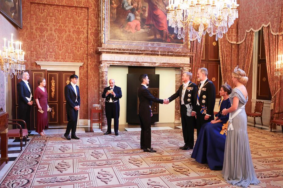 La dolencia que la reina Letizia (2d) sufre en su pie izquierdo, conocida como neuroma de Morton, le ha obligado a protagonizar una imagen insólita al participar sentada en el besamanos previo a la cena de gala ofrecida este miércoles por los reyes de los Países Bajos en el Palacio Real de Ámsterdam. EFE/ Casa De S.M. El Rey / José Jiménez