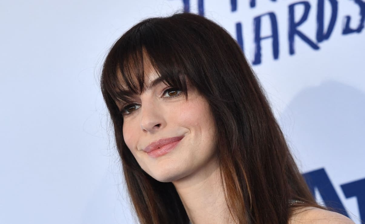Anne Hathaway luce radiante con minivestido plateado de lentejuelas
