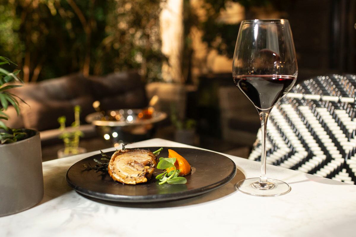 Porchetta mechada con pistache, almendra, ajo negro, clavo, frutas pasificadas, jus de ponche y puré de camote acompañado con una copa de vino Leca Cabernet Sauvignon. (Foto: Esteban Torreblanca)