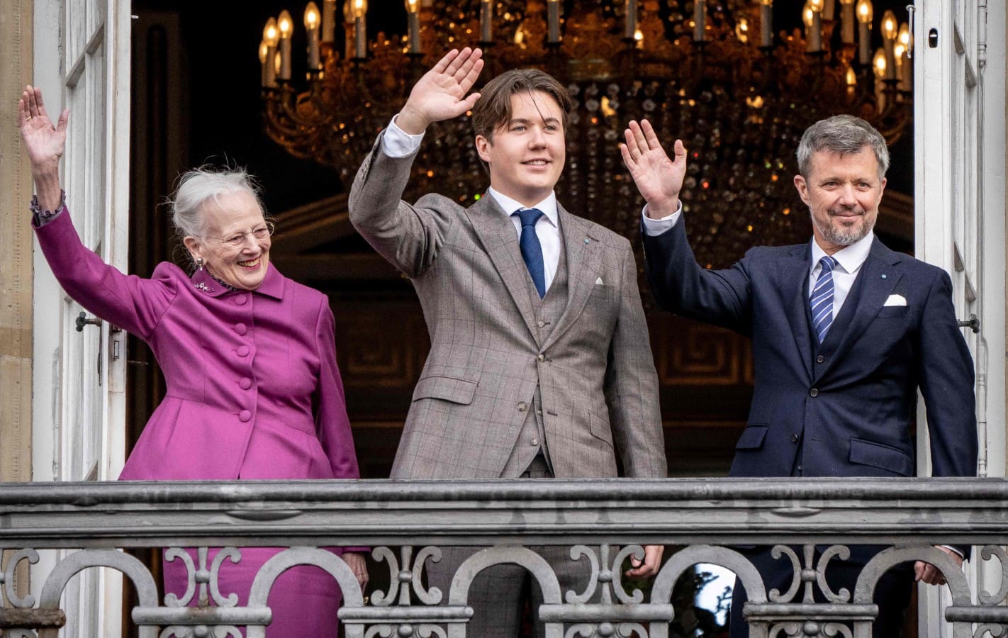 El príncipe Christian saludando desde el palacio Amalienborg con la reina Margarita de Dinamarca y su papá, el príncipe Federico / AFP